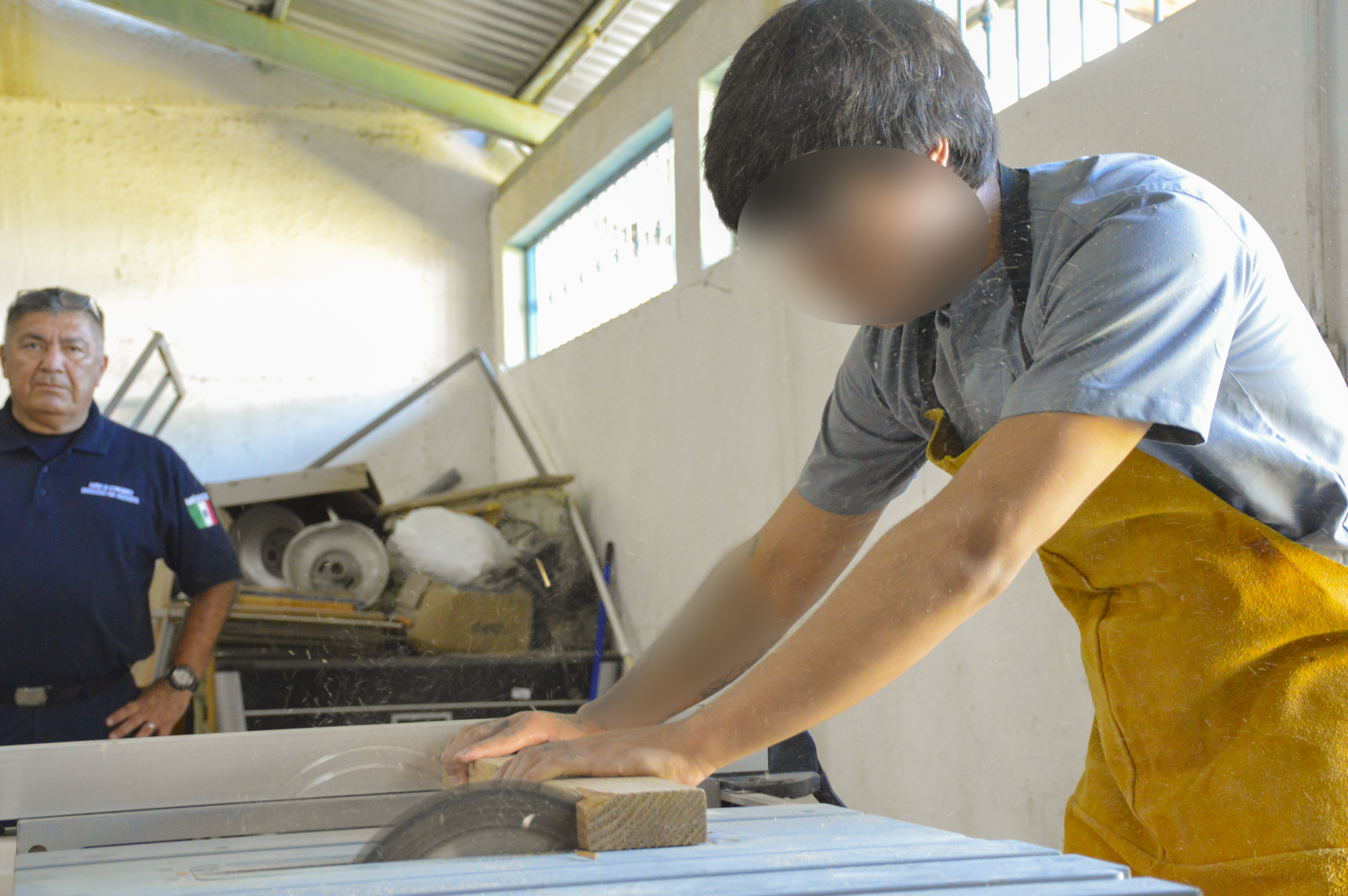 Participante del taller de carpintería con rostro protegido